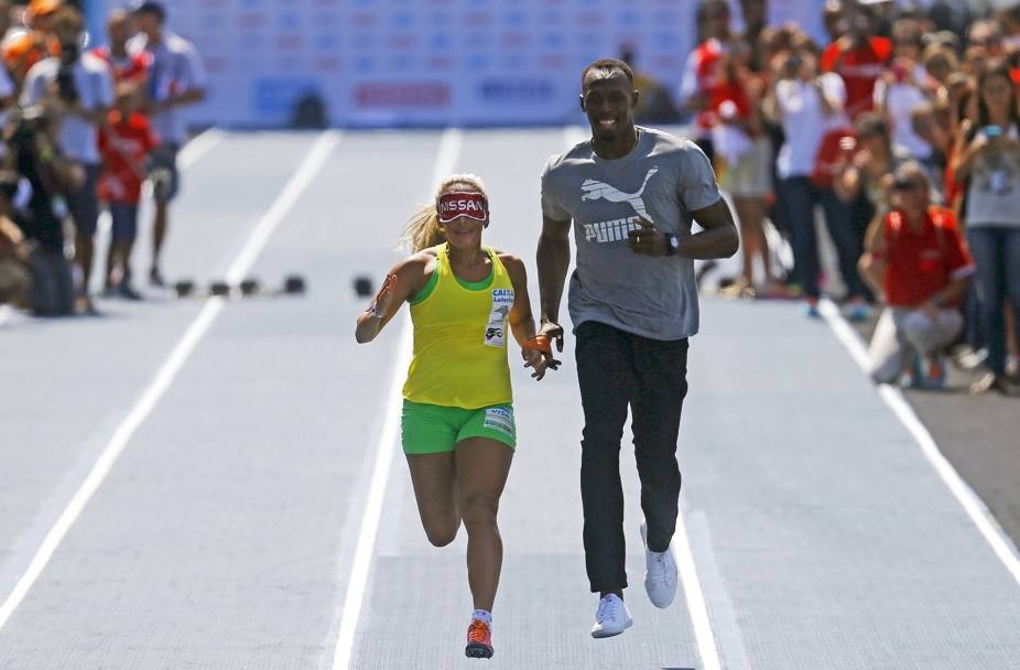 Usain Bolt, primatista mondiale di 100, 200 e staffetta 4x100, corre mano nella mano con l&#39;atleta paralimpica brasiliana Terezinha Guilhermina. Siamo a Rio de Janeiro, durante l&#39;evento 